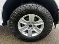 Close-up of a silver wheel and tire from a 2017 Ford F-150 featuring a distinctive five-spoke design and rugged tread suitable for off-road driving