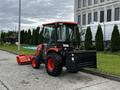 A 2018 Kubota B2650 tractor with a front loader attachment and large tires parked on a driveway