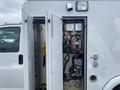 A 2014 Chevrolet Express with open double doors revealing a complex array of electrical wiring and control panels inside the vehicle