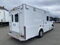 A 2014 Chevrolet Express van with a white body and rear entry doors