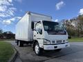 2007 GMC W5500 18 Foot Cube Van with a white exterior and chrome accents parked on a road with trees in the background