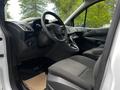 Interior of a 2014 Ford Transit Connect showing the steering wheel dashboard and driver’s seat with fabric upholstery