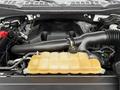 Engine components of a 2018 Ford F-150 showing the coolant reservoir and a part of the air intake system