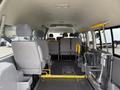 Interior of a 2009 Toyota Hiace showing rows of gray upholstered seats and a foldable wheelchair ramp on the right side