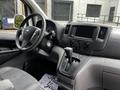 Interior of a 2020 Nissan NV200 showing the steering wheel gear shift and dashboard with controls and a display screen