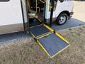 A 2017 Chevrolet Express with its side door open and a foldable ramp extended for accessibility
