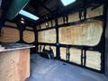 A 2022 Mercedes-Benz Sprinter van interior featuring insulation on the walls and a wooden surface in the foreground