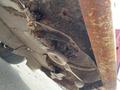 The underside of a 2012 Toro Groundsmaster 5910 showing rusted metal components and accumulated dirt with visible mechanical parts like blades and pulleys