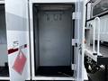 An empty storage compartment with no shelves or items visible featuring two hooks on the inside wall