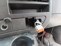 Interior view of a 2020 Chevrolet Express dashboard showing an open slot for a device connection with visible wires and a connector attached