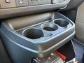 A close-up view of a cup holder section in the dashboard of a 2024 Chevrolet Express featuring three circular cutouts for beverages