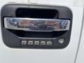 Close-up of the door handle of a 2014 Ford F-150 featuring a chrome finish and keypad with numbers 1 through 9