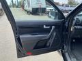 A 2015 Kia Sorento with an open door showing the interior door panel and control buttons for windows and locks