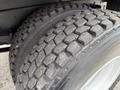 Close-up of a rugged tire from a 2004 Ford F-750 featuring a tread pattern designed for traction and durability
