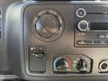 Control panel of a 2011 Ford Econoline featuring knobs for fan speed temperature and air conditioning settings