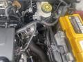 Engine compartment of a 2018 Buick Encore featuring components like the battery coolant reservoir and various wiring harnesses