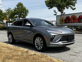 A 2024 Buick Envista stands parked with a sleek silver exterior and modern design features including an angular front grille and stylish alloy wheels