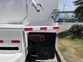 2015 Ford F-750 featuring a white body with red and white striped accents and visible plumbing components on the rear