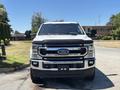 A white 2020 Ford F-350 SD pickup truck seen from the front with a chrome grille and large side mirrors
