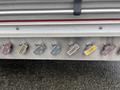 Close-up of a panel showing various colored push buttons labeled with different functions on a fire truck, specifically a 2006 E-One Typhoon model