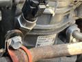 Close-up view of a 2022 Freightliner Cascadia engine component showing a label with model details and connections to various hoses and electronic plugs