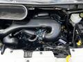Engine compartment of a 2015 Ford Transit showing the black engine cover along with various hoses and components in view