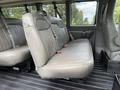 Interior view of a 2021 Chevrolet Express with gray vinyl bench seats and seatbelts visible