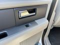 Interior view of a 2013 Ford Expedition door panel showing the door handle and control switch