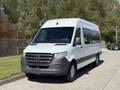 A 2023 Mercedes-Benz Sprinter van with a sleek design and silver paint parked on a street