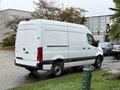 A 2023 Mercedes-Benz Sprinter van with a white exterior parked on a driveway showing its rear and side profile