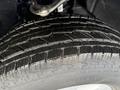 A close-up of a tire tread from a 2024 Chevrolet Silverado 1500 showing detailed grooves and wet surface for traction