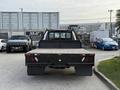 A black 2020 Ford F-550 truck with a flatbed is parked facing forward showcasing its rear lights and bed design