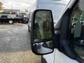 A close-up view of the side mirror of a 2020 Ford Transit with raindrops on the surface