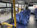 Interior view of a 2018 Chevrolet Express with blue upholstered seats and a yellow pole for support