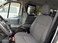 Interior of a 2019 Ford Transit showing two front seats with fabric upholstery and a steering wheel in the foreground