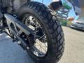 A close-up of a rear wheel of a 2022 Royal Enfield Himalayan showcasing a rugged tire and spoke design