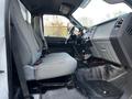 Interior view of a 2011 Ford F-750 showing two gray cloth seats and the dashboard with controls and gear shift