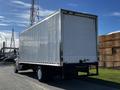A 2016 Freightliner M2 106 box truck with a white cargo area and black chassis parked on a paved surface