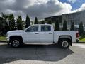 A white 2017 GMC Sierra 1500 pickup truck parked with a double cab and chrome wheels