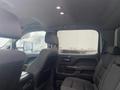 Interior view of a 2015 GMC Sierra 1500 showing two rows of dark fabric seats and door panels with wood accents