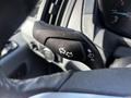 A close-up of the turn signal lever inside a 2017 Ford Transit showing directional arrow icons and buttons for lights and windshield wipers