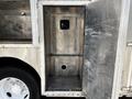 A silver metal compartment door of a 2008 Morgan Olson Workhorse with a hollow interior and a circular hole in the bottom