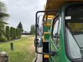 A 2015 Freightliner M2 106 truck with a green and yellow exterior featuring a side mirror and a sturdy frame