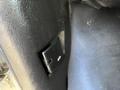 A black plastic latch attached to the interior wall of a 2014 Chevrolet Express van