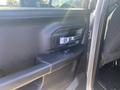 The interior door handle of a 2021 RAM 1500 featuring a chrome accent and a window control button