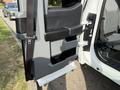 A 2023 Ford F-550 truck door with a black handle and storage compartment visible
