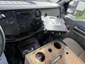 Interior of a 2008 Ford F-450 showing the dashboard with controls a mounted tablet holder and a wooden center console with cup holders