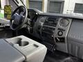 Interior view of a 2016 Ford F-550 featuring a steering wheel dashboard and center console with audio controls and storage compartments