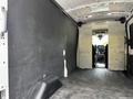 Interior view of a 2022 Ford Transit cargo van showing a spacious empty cargo area with a bulkhead and a smooth floor