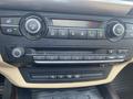 Dashboard of a 2009 BMW X5 featuring climate control knobs audio system buttons and a display screen